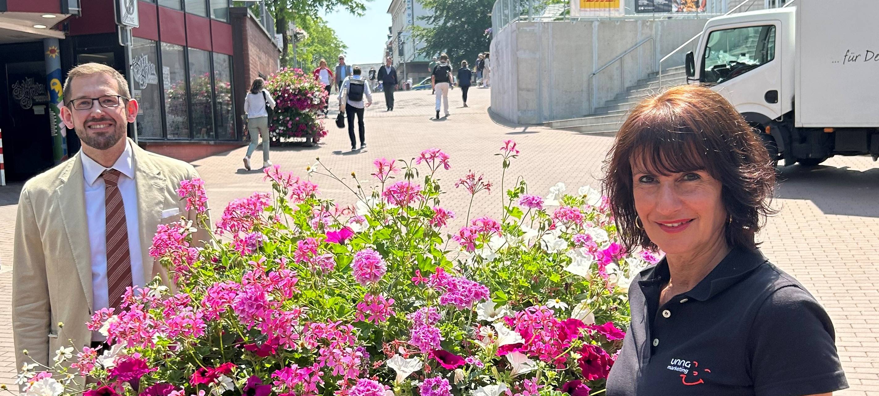 Unnas Erster Beigeordneter Sandro Wiggerich und Daniela Guidara vom Stadtmarketing Unna samt Blumenpyramide am Königsborner Tor.