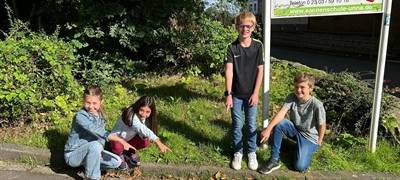 Marie, Leonie, Matti und Ben (von links) zeigen die frisch erneuerten Markierungen im Einfahrtsbereich zum Schulhof der Sonnenschule.