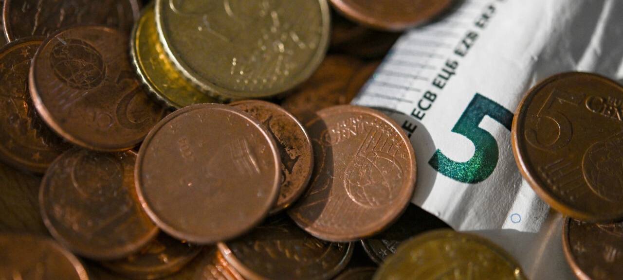 Geldmünzen und ein 5 Euro-Schein liegen in einer Schale. Das Statistische Bundesamt will die Inflationsrate für Oktober 2024 am 30.10.2024 bekannt geben.