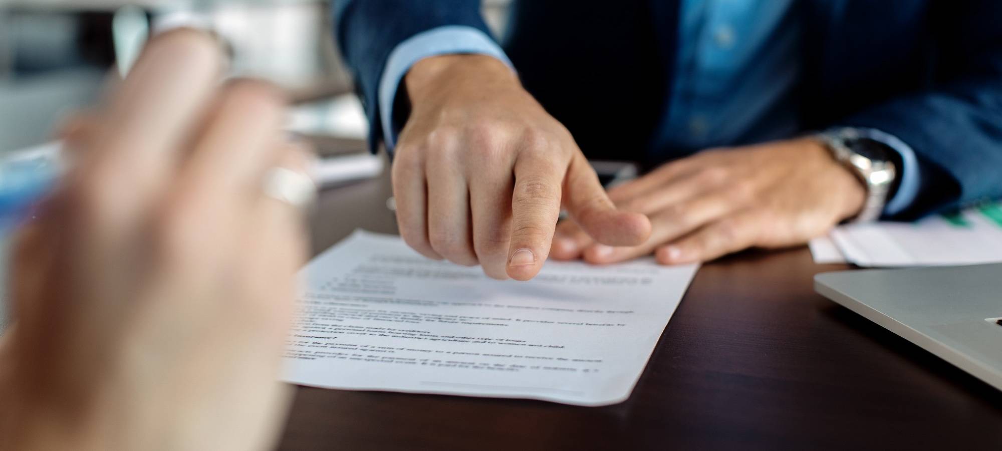 Zwei Menschen mit einem Vertrag in der Mitte.