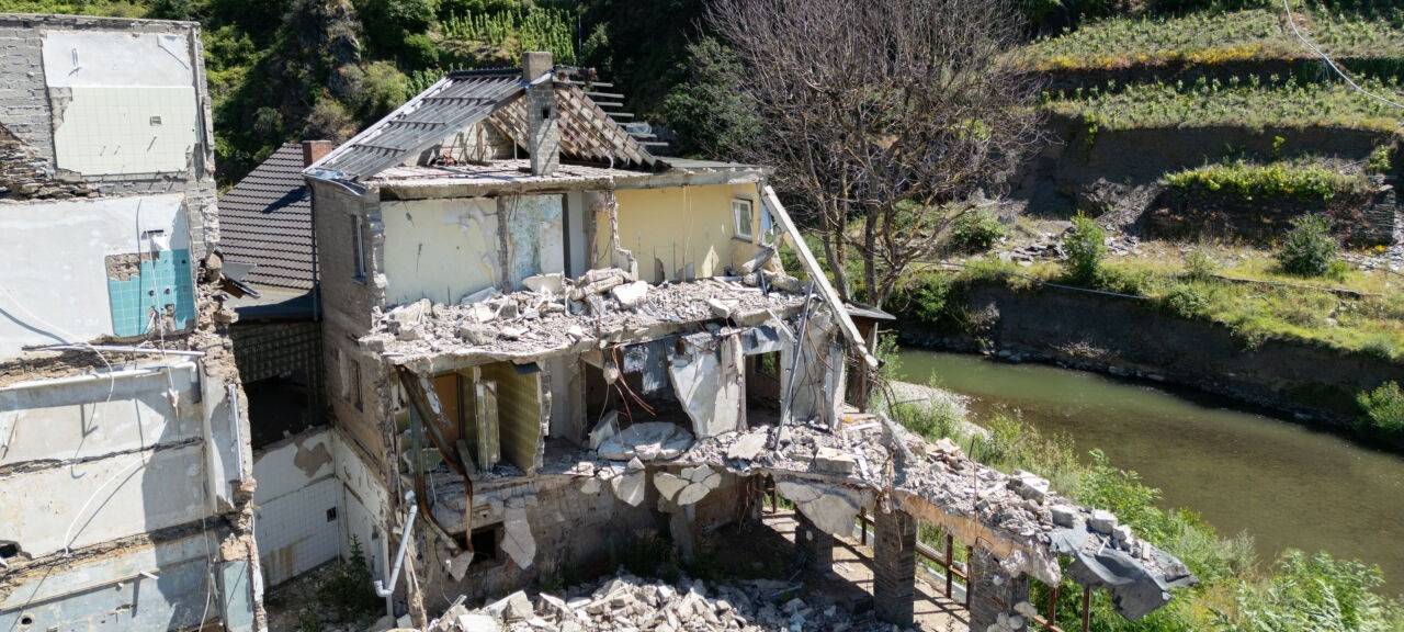 Die Ruinen von zwei bei der Flut im Sommer 2021 zerstörten Wohnhäusern stehen am Ufer der Ahr (Luftaufnahme mit einer Drohne). (Zu dpa „Ohnmacht und Rückzug - das Ahrtal drei Jahre nach der Flutkatastrophe“)