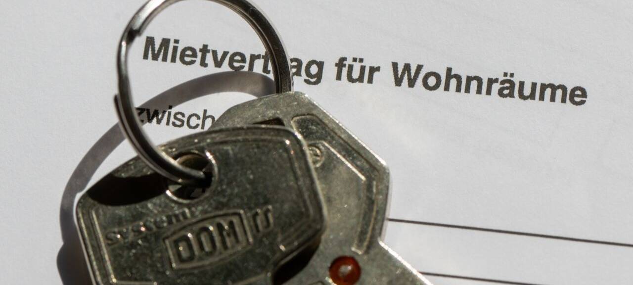 Ein Wohnungsschlüssel liegt auf einem Mietvertrag für eine Wohnung.