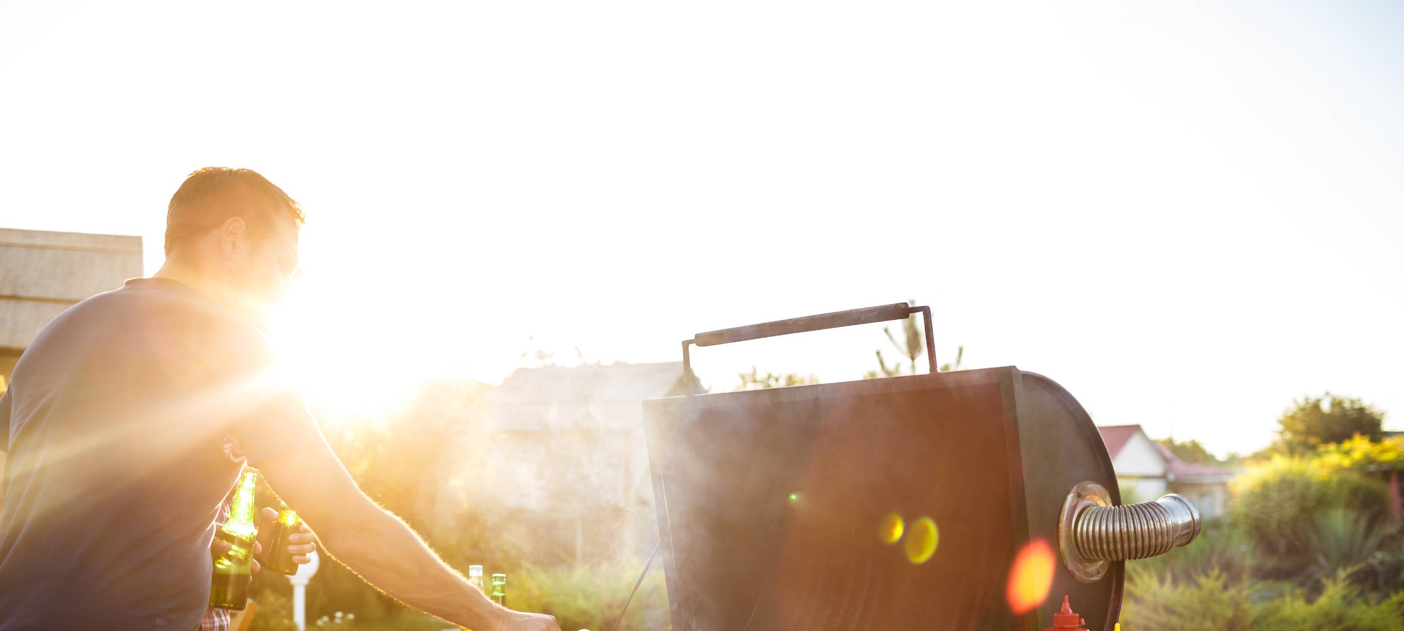 Mann grillt an Gasgrill