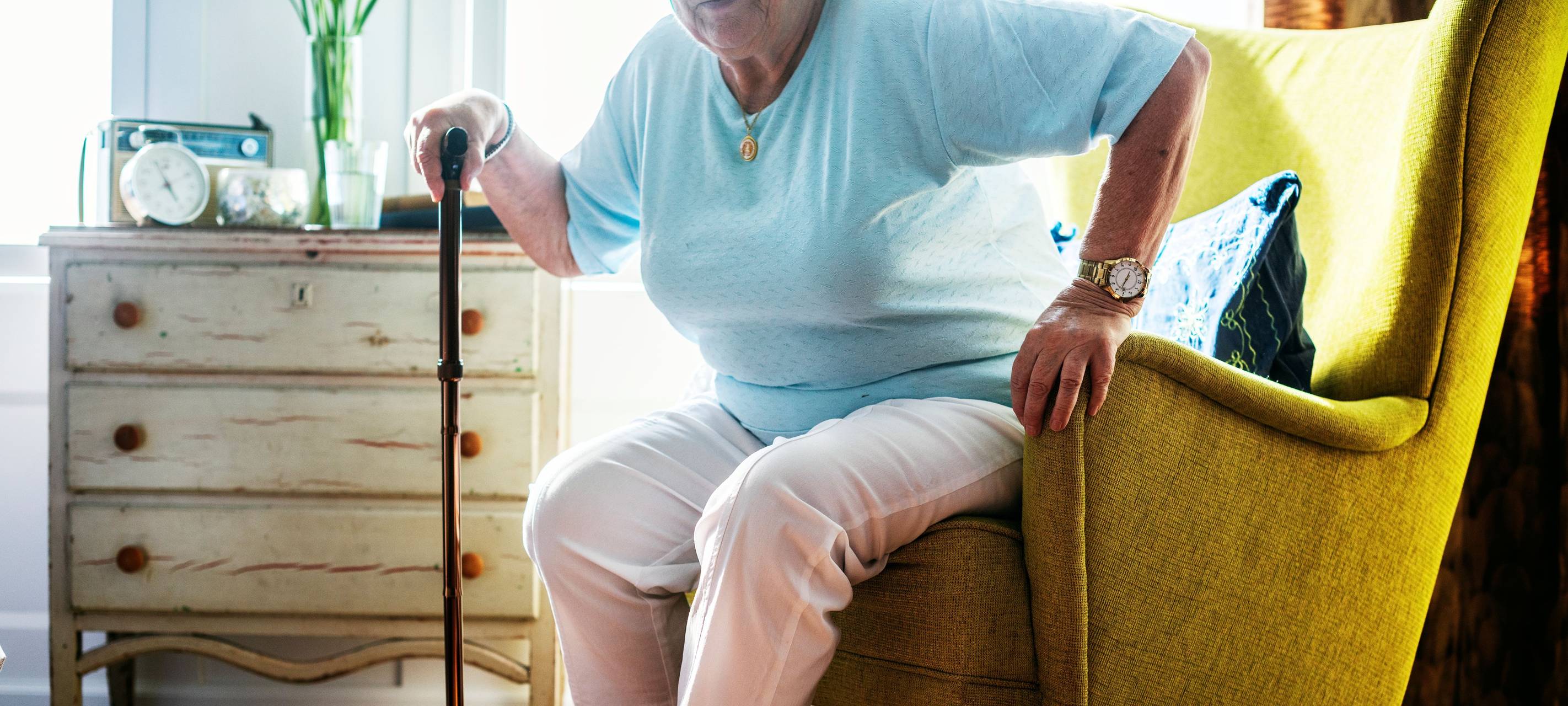 Ältere Dame sitzt auf einem Sessel