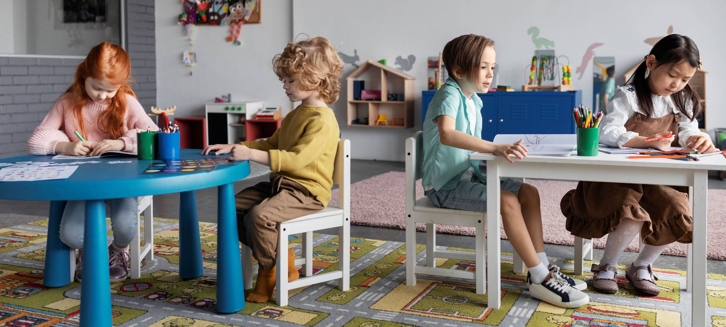 Kinder malen an Tischen in der Kita