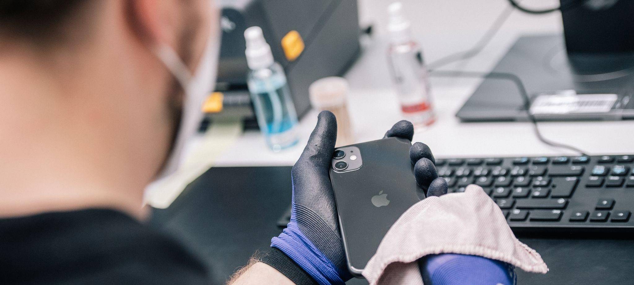 Ein Mitarbeiter überprüft ein refurbished Iphone