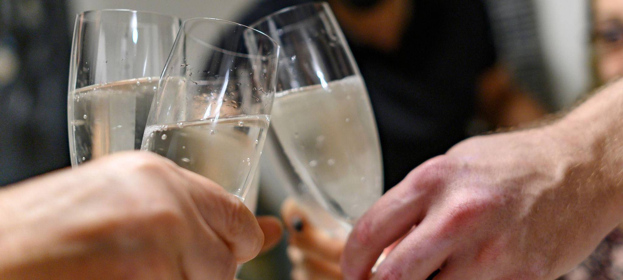 Mehrere Personen halten Sektgläser in den Händen