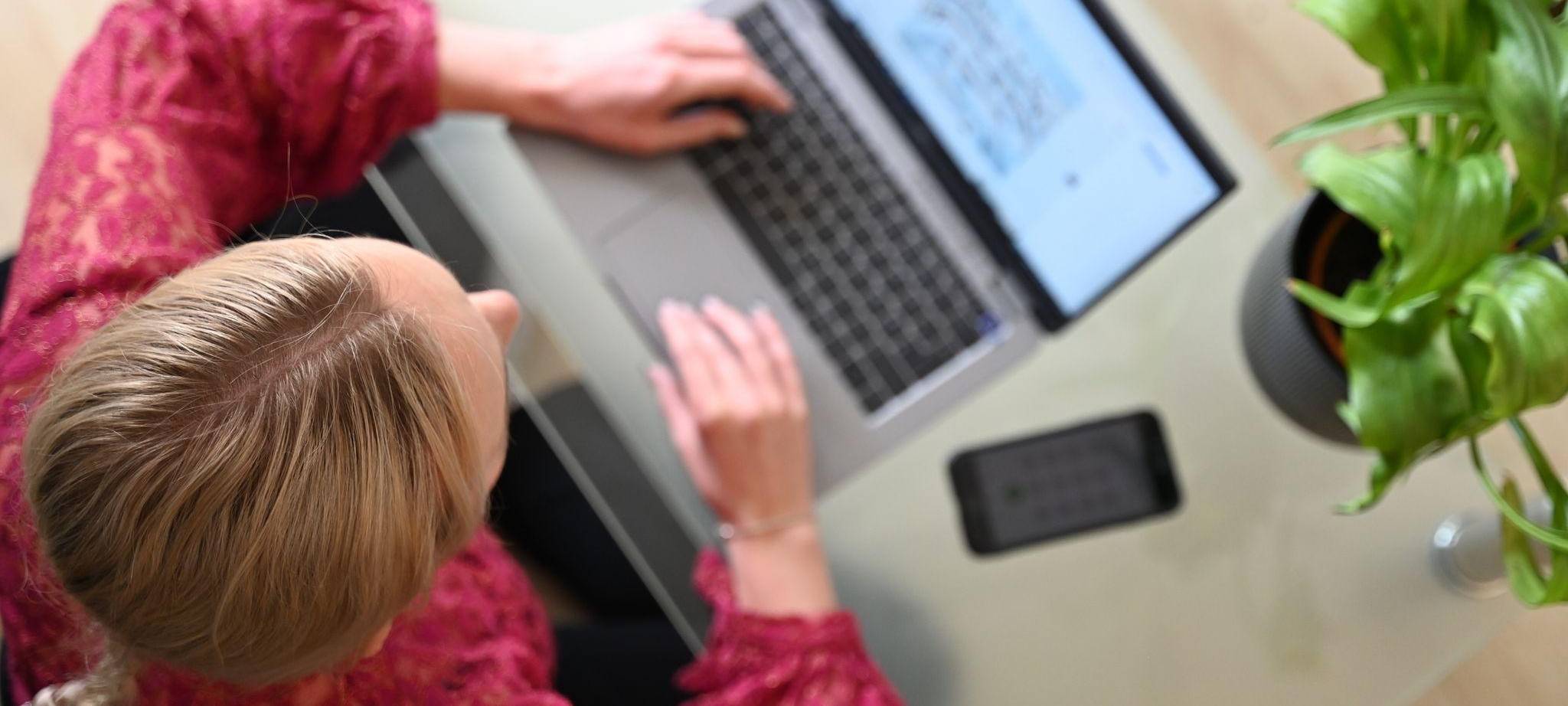 Eine Frau sitzt zuhause an einem Laptop