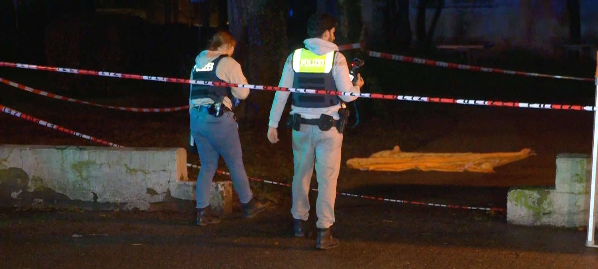 Zwei Einsatzkräfte der Polizei machen Fotos am Tatort in Lünen