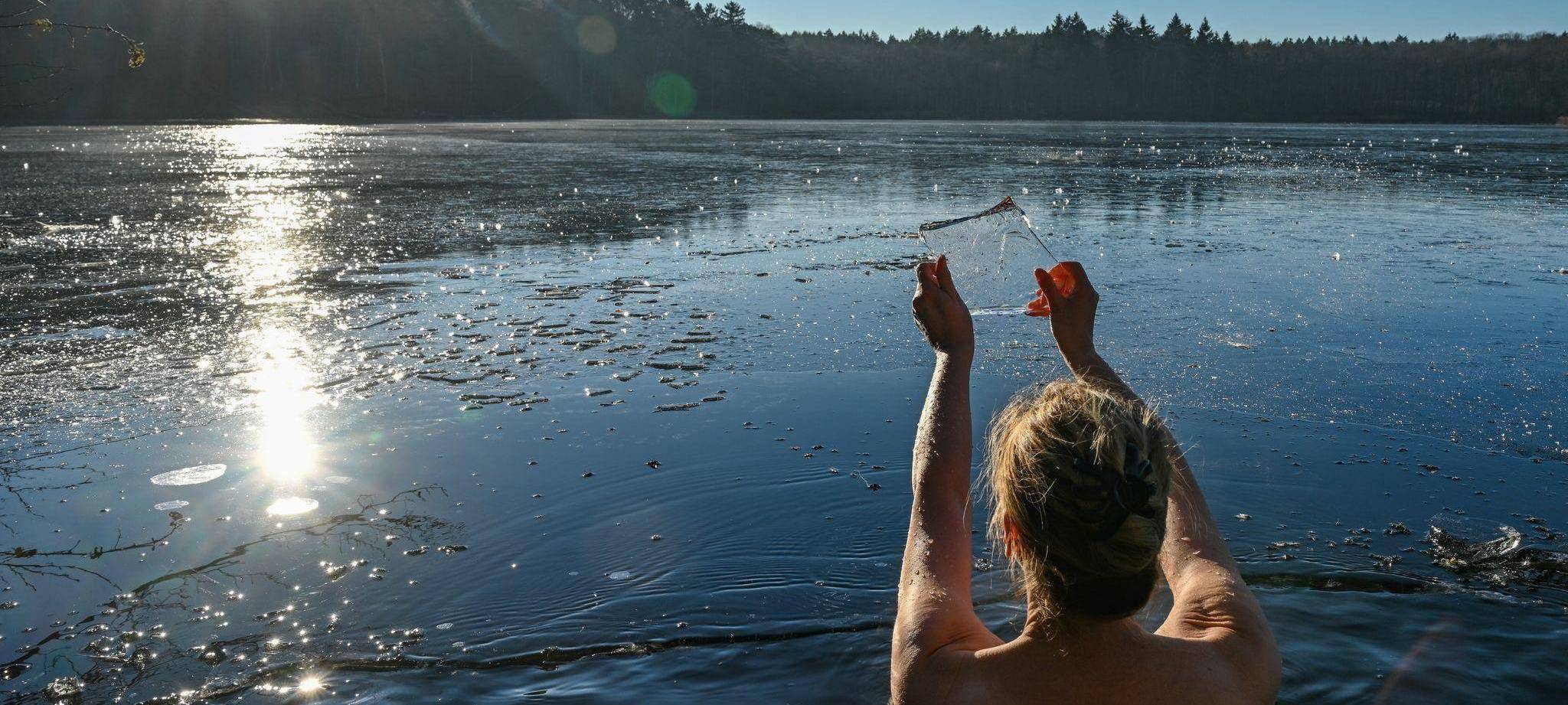 Eine Frau badet in einem fast zugefrorenen See